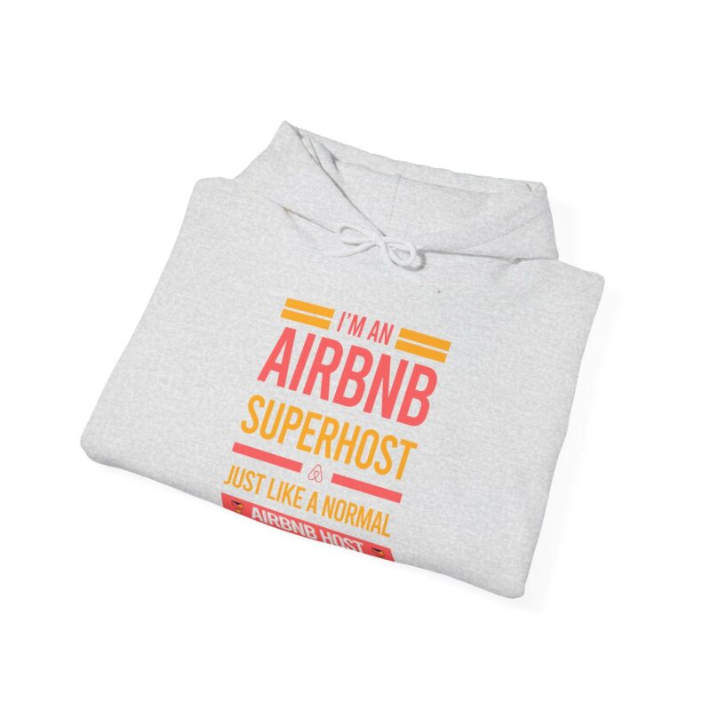 A folded "I'm an Airbnb Superhost Unisex Heavy Blend Hooded Sweatshirt" in gray, featuring the text "I'm an Airbnb Superhost, just like a normal Airbnb host but cooler" printed on the front in orange, pink, and peach colors.