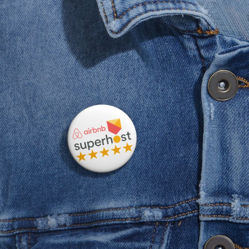 A pin from the Airbnb Superhost Pin Buttons collection, featuring the Superhost logo and five stars as a testament to mastering Airbnb hosting, is attached to a denim jacket.