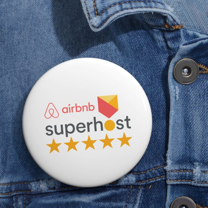 An Airbnb Superhost Pin Button gleams with five stars on a denim jacket, representing the highest standard in Airbnb Hosting excellence.