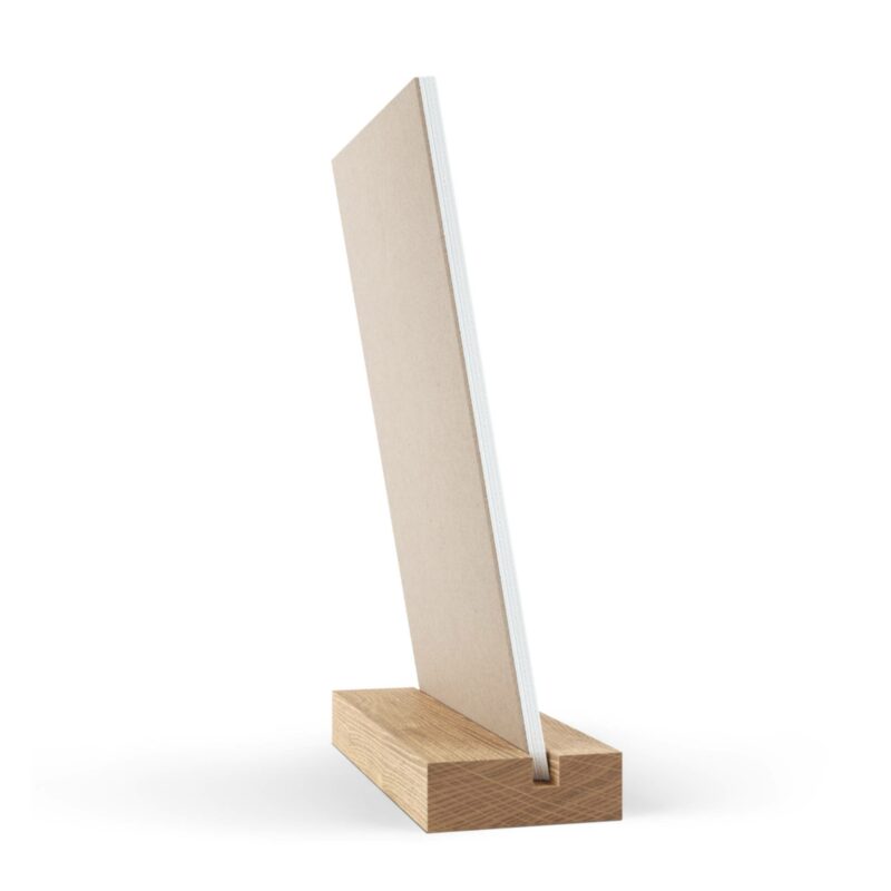 A rectangular piece of cardboard, known as the Vertical Desk Calendar (2022), held upright by a wooden base with a slot.