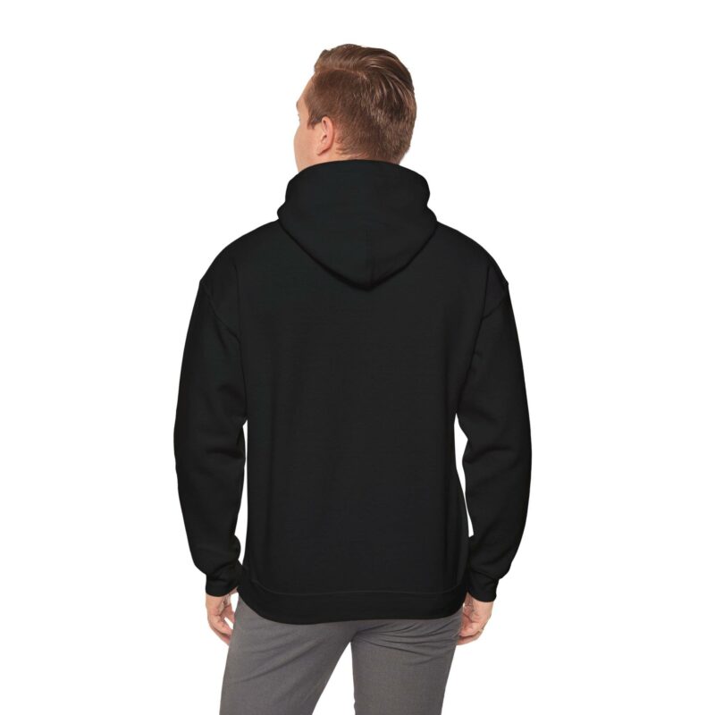 A person wearing the "I'm an Airbnb Superhost" unisex heavy blend hooded sweatshirt and gray pants is standing with their back to the camera.