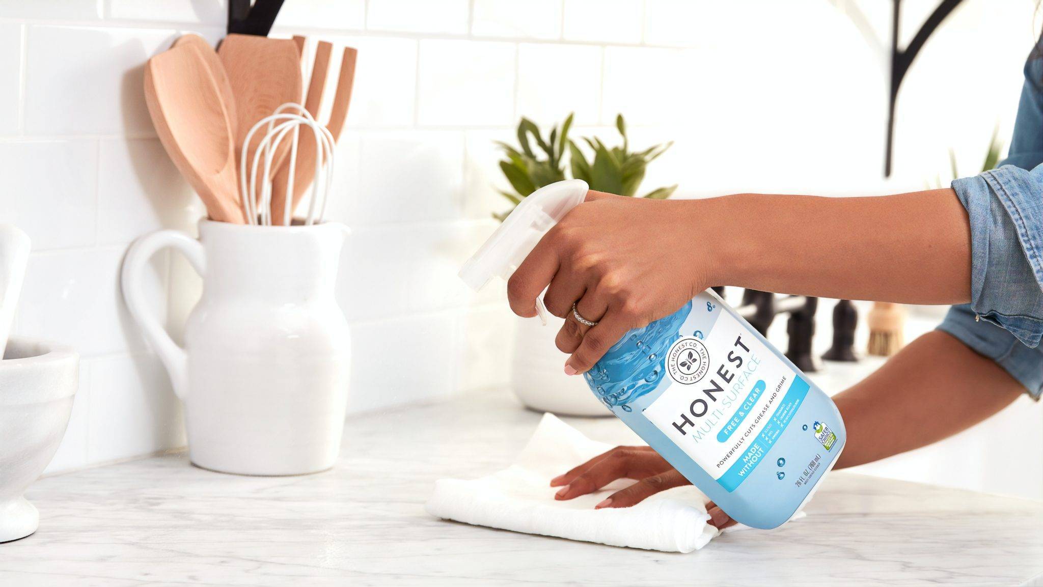 Airbnb Hosting A woman is cleaning a kitchen counter at an Airbnb hosting location.