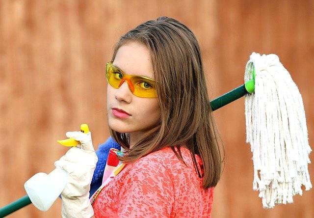 Airbnb Hosting A young woman holding a mop.