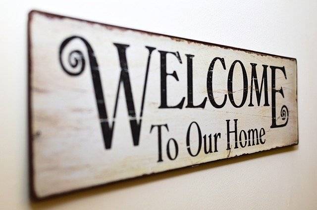 Airbnb Hosting A black and white welcome sign hanging on a wall.