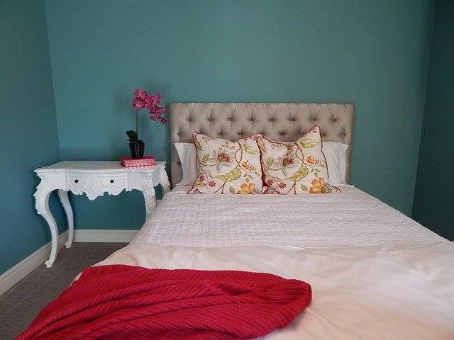 Airbnb Hosting A teal-themed bedroom with a white bed for Airbnb.