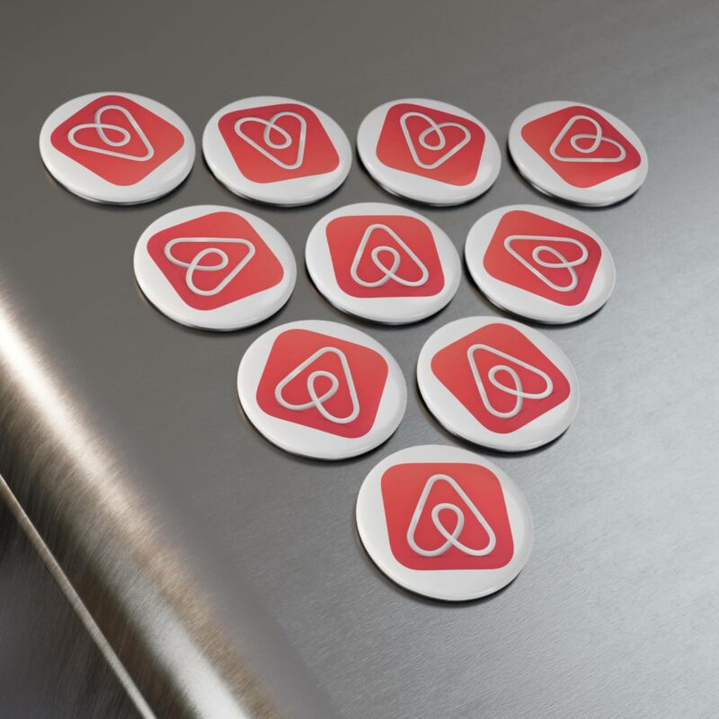 A set of 10 Airbnb Button Magnets, each featuring a red and white logo, arranged in a triangular pattern on a metallic surface.