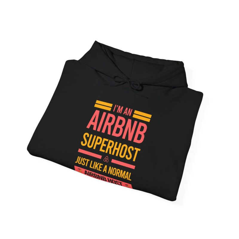 A folded "I'm an Airbnb Superhost Unisex Heavy Blend Hooded Sweatshirt" in black with colorful text reading, "I'm an Airbnb Superhost just like a normal Airbnb host.