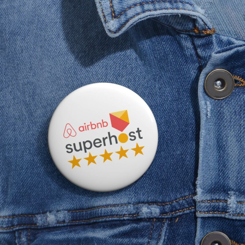 The Airbnb Superhost Pin Buttons, featuring the iconic logo and five stars, are proudly showcased on a denim jacket, symbolizing the mastery of Airbnb hosting tips.