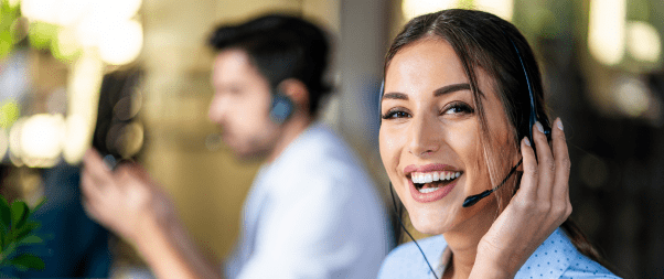 Airbnb Hosting A woman wearing a headset and smiling at the camera while implementing Airbnb Slow Season Strategies for maximizing bookings and profits.