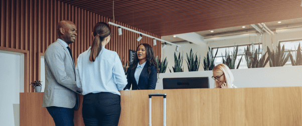 Airbnb Hosting A group of Airbnb hosts standing at a reception desk, discussing revenue streams.