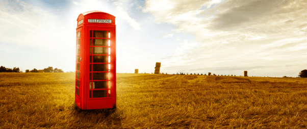 Airbnb Hosting A red telephone booth in a field providing essential contact information for an Airbnb.