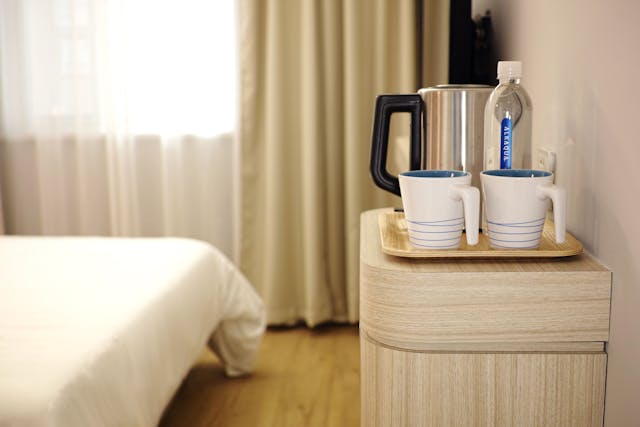 Enjoy complimentary tea and coffee from the comfort of your bedside in our bright, minimalist room.
